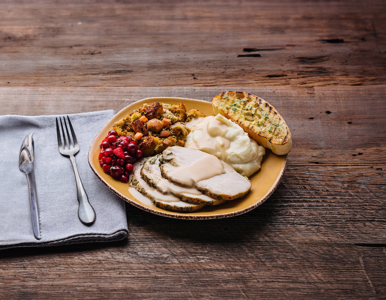 Turkey plate with mashed potatoes, stuffing, cranberry relish and garlic bread